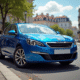 Voiture Peugeot 308 bleue en ville en plein jour